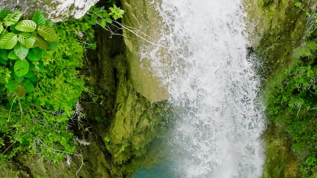 Aerial drone of waterfall in the jungle in slow motion. Inambakan Falls in the rainforest. Cebu, Philippines.