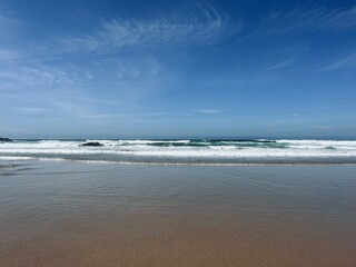 Blue sea horizon, sandy coast, waved, blue sky