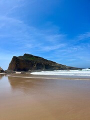 Rocky ocean coast, ocean bay with rocky coast and sand beach, blue sky, no people