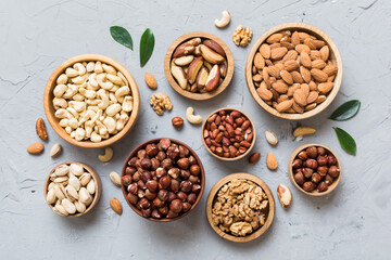 mixed nuts in wooden bowl. Mix of various nuts on colored background. pistachios, cashews, walnuts, hazelnuts, peanuts and brazil nuts