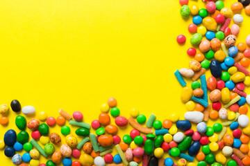 Mixed collection of colorful candy, on colored background. Flat lay, top view. frame of colorful chocolate coated candy