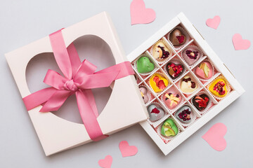 Valentine day composition: sweet candy, with gift boxes with bow and red felt hearts, photo template, background. Top View with copy space