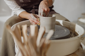 Close up of artisan's hands shaping clay bowl in pottery studio. Pottery art and creativity