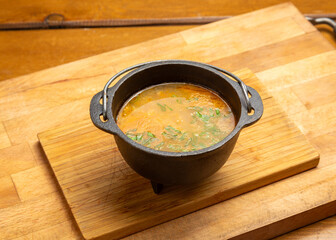 Pea soup in a cast iron pot on a wooden board