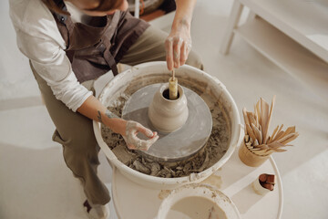 Close up of artisan's hands shaping clay bowl in pottery studio. Pottery art and creativity