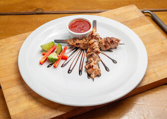Chicken kebab on a plate on a wooden board