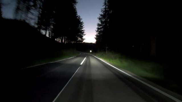 driving a car on countryside road at night with adaptive matrix headlights