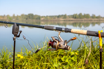 A rod and reel in the background of the lake. Fishing, recreation, hobby. Close-up