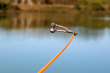 bell alarm is on fishing rod spinning in nature bells of allure are attached to the end of the...