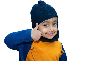 An Asian boy wearing a monkey cap showing a thumbs-up sign is using his hand.