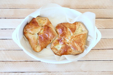 Puff buns with cheese on a tray on a wooden background