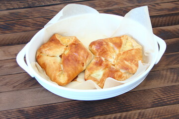 Puff buns with cheese on a tray on a dark wooden background