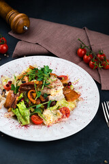 Georgian food salad with bacon, lettuce, cherry tomatoes, onion, pomegranate seeds and pepper.