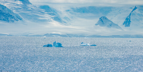 Melting icebergs and ice floats along the sunny shores of Paradise Bay, Gerlach Straight, Antarctica