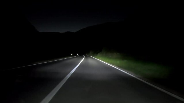 driving a car on countryside road at night with adaptive matrix headlights