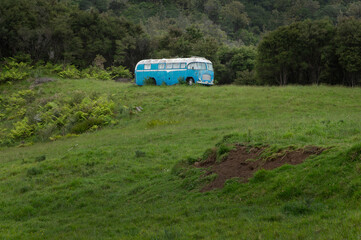 Abandoned blue oldtimer bus on the hills. Pukeinoi. Coast West New Zealand.