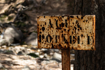 Rusty sign on abandoned settlement in the forest