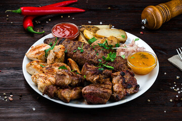 Portion barbecue with beef, pork, chicken, potatoes, onions and sauce.