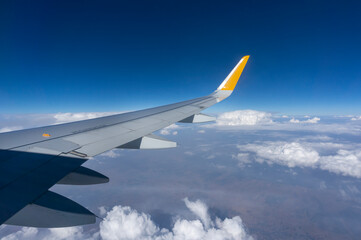 Fototapeta na wymiar Airliner Flying Over Clouds And Landscape