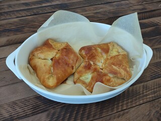 Baked puff pastry buns with cheese khachapuri on the wooden background