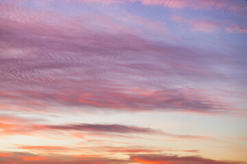 A beautiful sky tinted by the sun leaving vibrant shades of gold, pink, blue and multicolored. Clouds in the twilight evening and morning sky. Cloudy sky background in the evening and during the day.