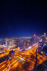 Fototapeta na wymiar Night cityscape of center Dubai, aerial top view. Skyscrapers illuminated and highway of UAE