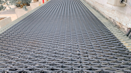 Grating walkway and handrail.External fire escape with open mesh flooring, Structural steel...