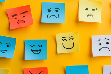 Testimonial rating concept with emotion faces on colorful sticky notes on yellow background. various different mood faces drew on sticky notes, cute colorful hand-drawn emoji drawing wallpaper concept