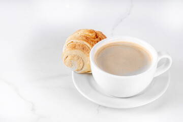 Black espresso coffee cup with croissant and coffee beans, simple traditional french breakfast 