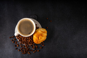 Black espresso coffee cup with croissant and coffee beans, simple traditional french breakfast 