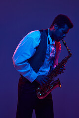 African-American man in shirt and vest playing saxophone against blue and purple background in neon...