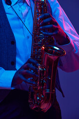 Cropped photo of African-American jazz-man playing saxophone, wind instrument against gradient...