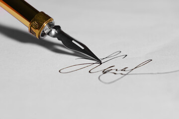 Signing on sheet of paper with fountain pen, closeup