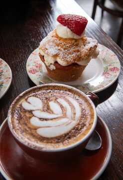 Having a coffee. Capuchino cup. With pastry strawberry. Cuba street Wellington New Zealand.