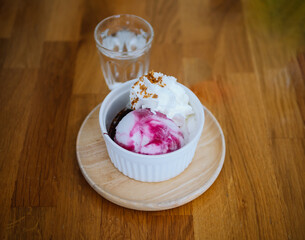 Homemade yogurt and blueberry ice cream with natural blueberry syrup in a bowl on a rough blue background. Top view of yogurt and blueberry ice cream with natural blueberry syrup