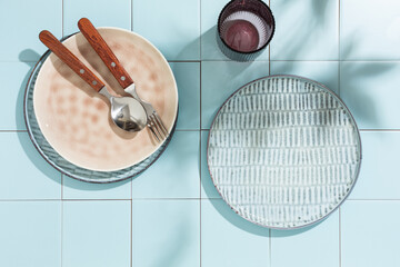 Clean dishes, plates, glasses, cutlery on a blue tiled background. . Copy space. Top view.