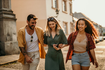  Three female and male friends having a great time in the heart of the city