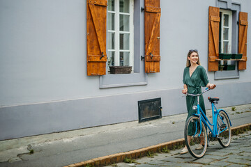 Young lady in a summer dress, navigating the city streets with her bicycle
