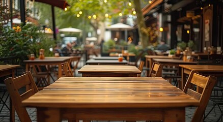 Fototapeta premium Elegant wooden table in restaurant with blurred bokeh background. Vintage cafe ambiance with cozy interior design. Abstract business setting in pub with retro decoration perfect for dining