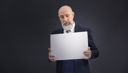 Portrait corporate d'un homme d'affaires en costume et avec barbe qui tient un panneau affiche blanc