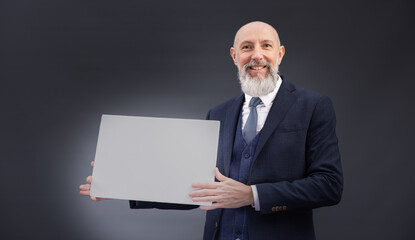 Portrait corporate d'un homme d'affaires en costume et avec barbe qui tient un panneau affiche blanc