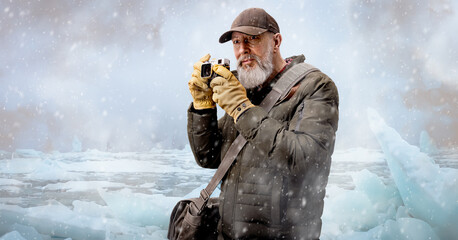 Homme aventurier photographe quinquagénaire qui réalise un trekking en hiver dans une région glaciaire