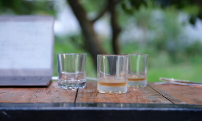 Glasses with whiskey at bottom are on table in bar closeup. Alcohol addiction concept