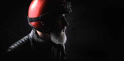 Portrait d'un motard homme avec un casque et une veste en cuir et des lunettes de protection et une...