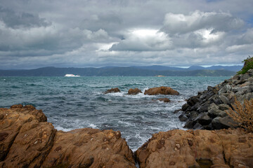 Rocks and interislander ferry. at Halswell point. Wellington New Zealand. Bay. Sea. Coast.