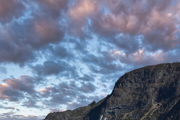 Westcap in Norway. Mountain that reaches into the fjord. Cloudy sky with clouds