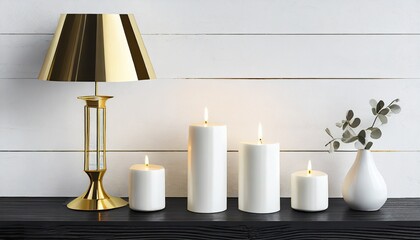 composition of white candles and gold stylish table lamp in mid century modern design standing on...