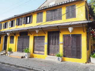 Yellow building with brown doors and shutters in Hoi An Ancient Town