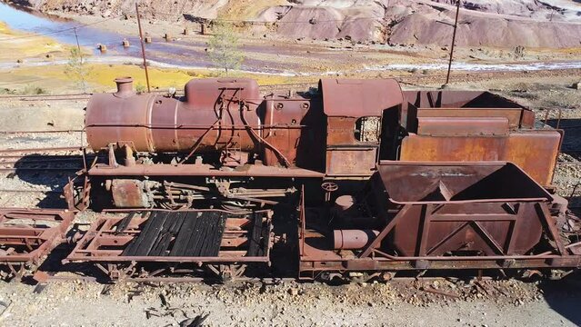 Aerial drone view of an old and rusty steam mining train used for transportation of the copper of  Corta Atalaya mining exploitation. Remains of the old copper mining operation in Minas de Riotinto