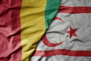 Fototapeta premium big waving national colorful flag of northern cyprus and national flag of guinea .